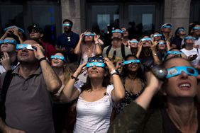 People view the solar eclipse at 'Top of the Rock' observatory at Rockefeller Center, August 21, 2017 in New York City. 