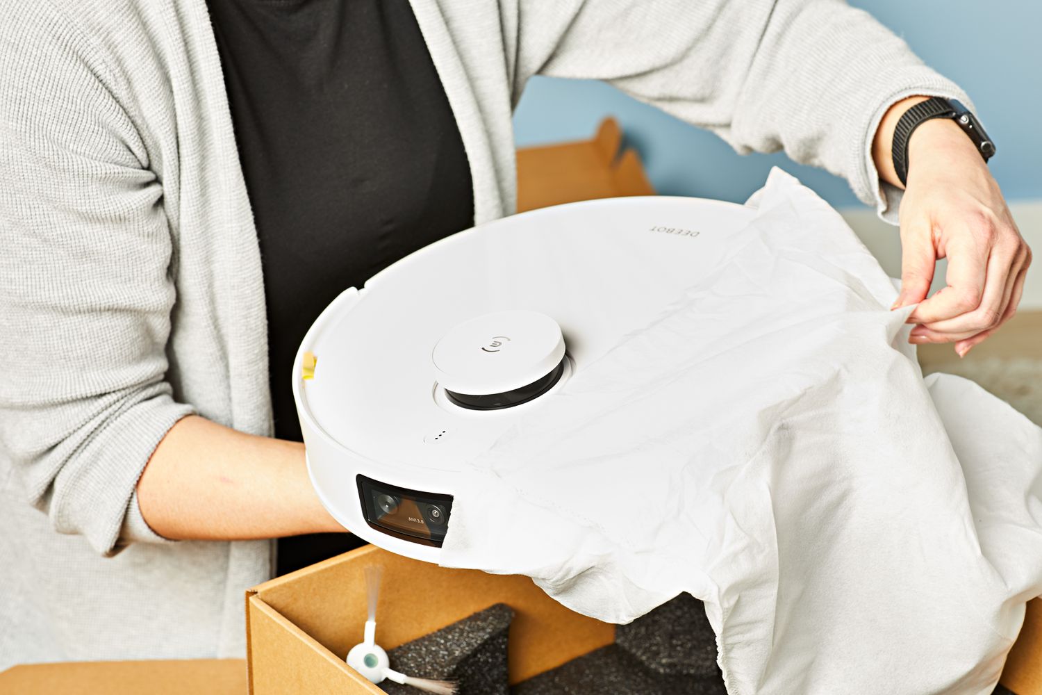 Person unboxing Ecovacs Deebot T10 Plus Robotic Vacuum and Mop on a table 