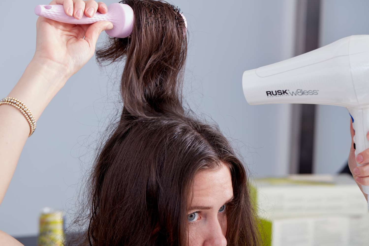 Closeup of a person blowdrying their hair Rusk W8less Professional 2000 Watt Dryer and a brush