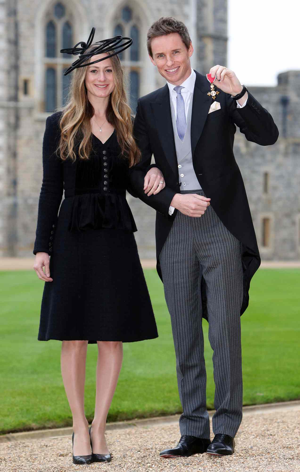 Eddie Redmayne poses with his wife Hannah after he was made an OBE (Officer of the Order of the British Empire) by Queen Elizabeth II during an investiture ceremony at Windsor Castle on December 2, 2016 in Windsor, England