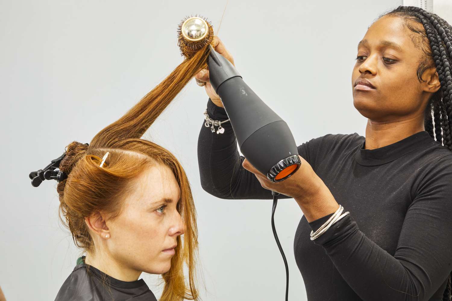 Person blowdrying another person's hair with BaBylissPRO Porcelain Ceramic Carrera2 Dryer and a brush