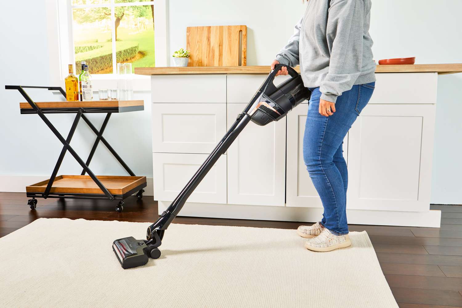 Person cleaning a beige carpet with the Miele Triflex HX2 Cat & Dog Vacuum