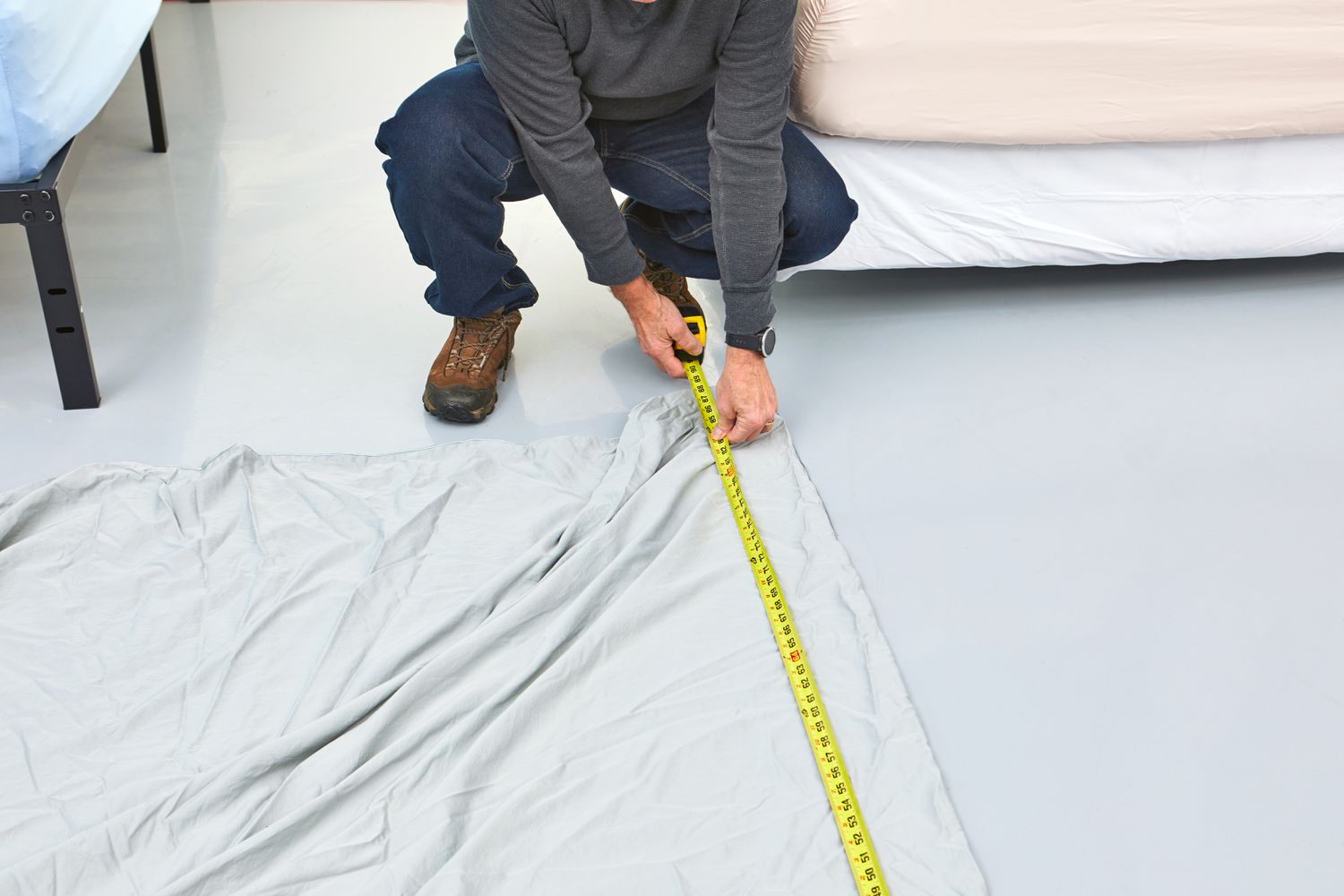 Person using measuring tape to measure Slumber Cloud Essential Duvet Cover on the floor