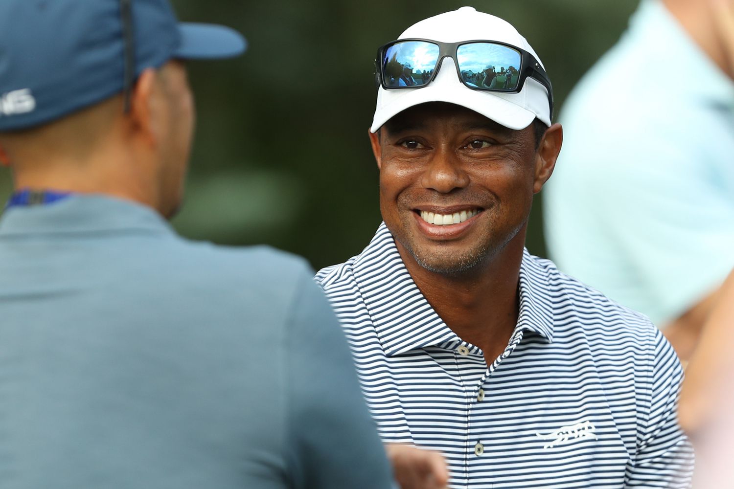 Tiger Woods of the United States talks with spectators near the putting green on day one of the 76th 