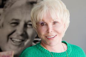 Joan Benedict Steiger poses in front of a photo of her late husband, actor Rod Steiger in 2013 at her home in Malibu, California