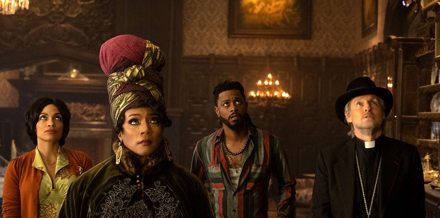 Rosario Dawson as Gabbie, Tiffany Haddish as Harriet, LaKeith Stanfield as Ben, and Owen Wilson as Father Kent in Disney's live-action HAUNTED MANSION