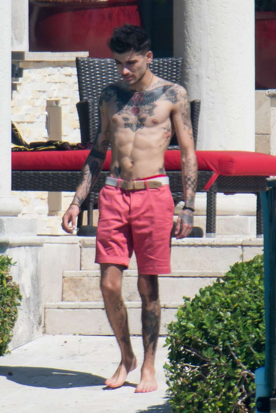 Shirtless Zayn Malik is seen holding a water fan to cool down from the Florida heat while chatting to a blonde female