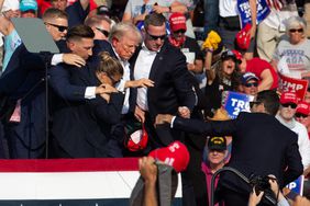 Republican candidate Donald Trump is seen with blood on his face surrounded by secret service agents as he is taken off the stage at a campaign event at Butler Farm Show Inc. in Butler, Pennsylvania, July 13, 2024. 