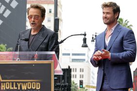Robert Downey Jr. and Chris Hemsworth speak during the Hollywood Walk of Fame Star Ceremony honoring Chris Hemsworth on May 23, 2024 in Hollywood, California.