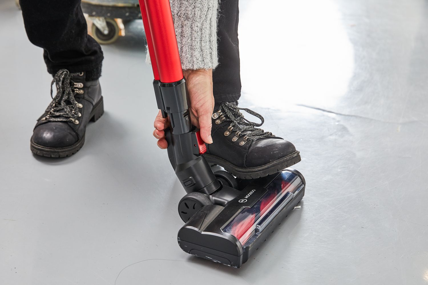 Person with their foot on the Moosoo K23 Pro Cordless Stick Vacuum