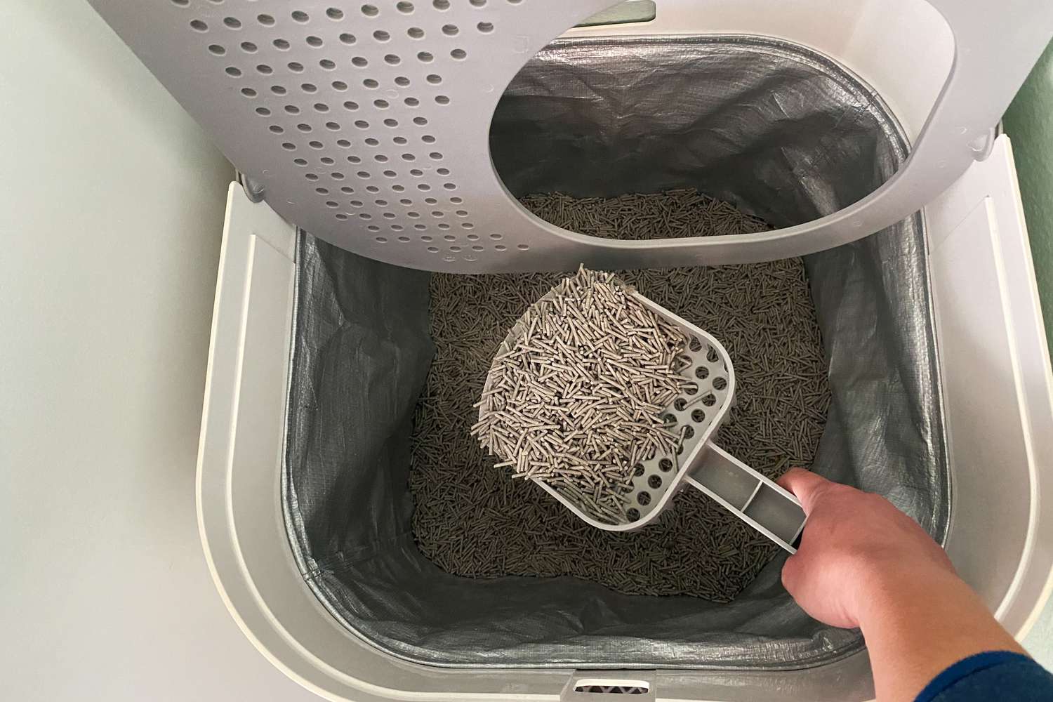 Person scooping up Tuft and Paw Really Great Cat Litter from a litter box