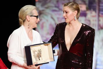 President of the Jury Greta Gerwig (C) and Jury Member Nadine Labaki (R) congratulate Meryl Streep for receiving the Honorary Palme DOr Award