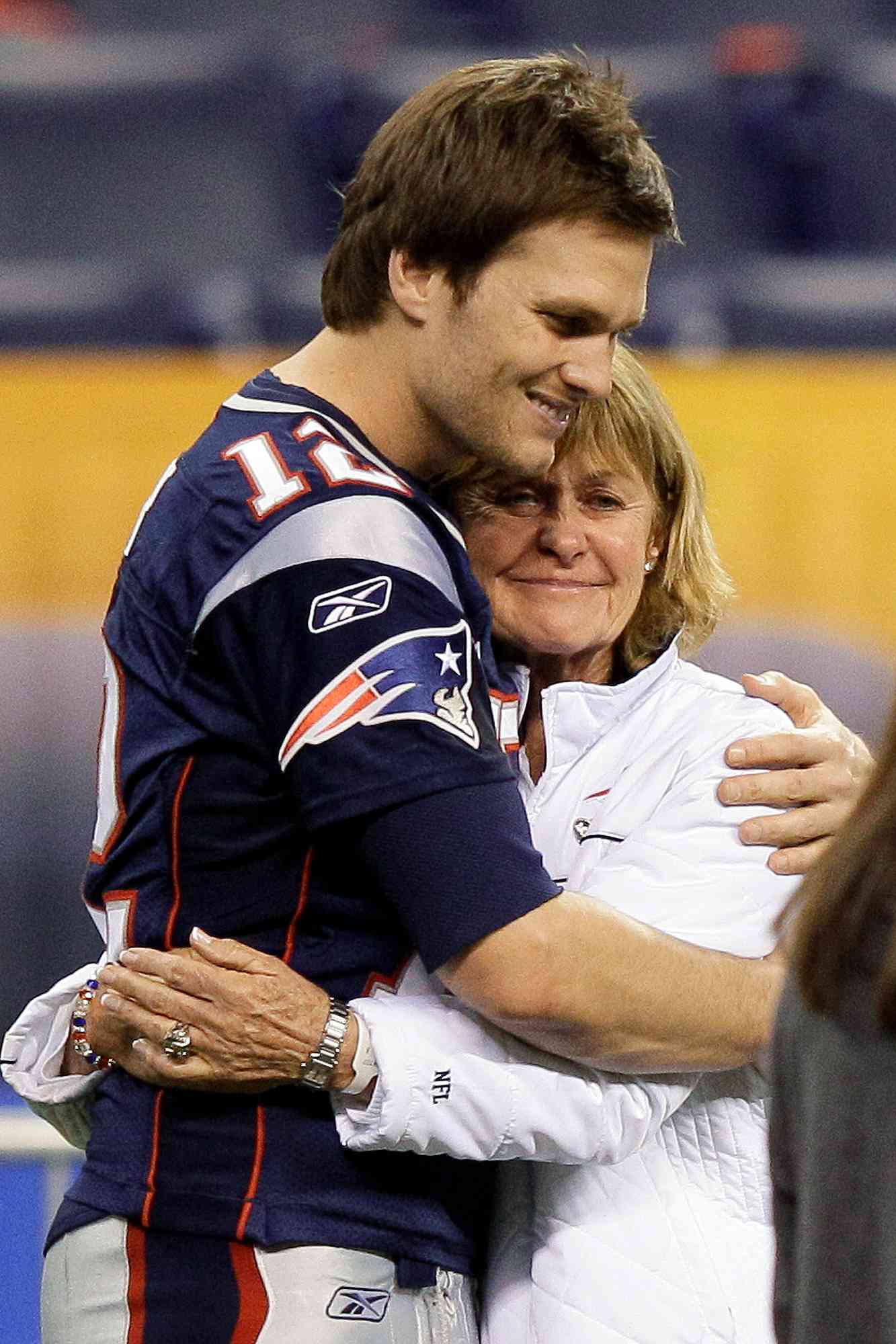 In this Feb. 4, 2012, file photo, New England Patriots quarterback Tom Brady (12) hugs his mother, Galynn, in Indianapolis. The Patriots visited with family and friends on the field the day before they are scheduled to face the New York Giants in NFL football Super Bowl XLVI on Feb. 5.