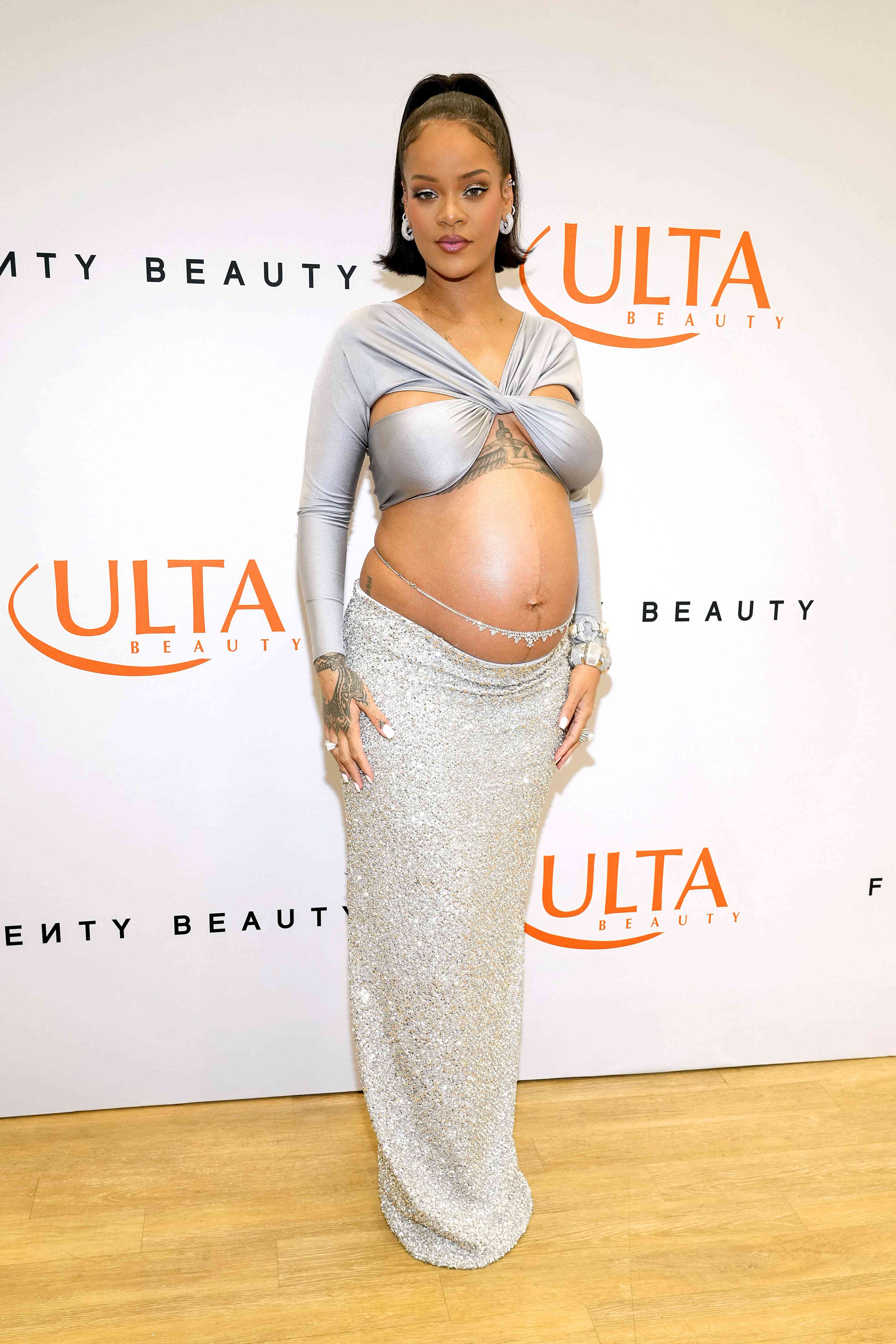 A pregnant Rihanna in a cropped gray top and shimmery silver maxiskirt