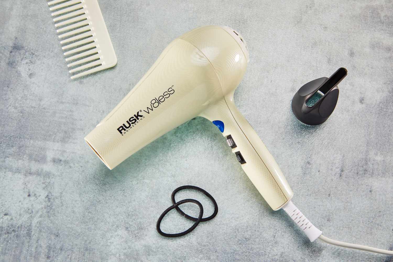 Rusk W8less Professional 2000 Watt Dryer and its attachment displayed with a comb and hair ties