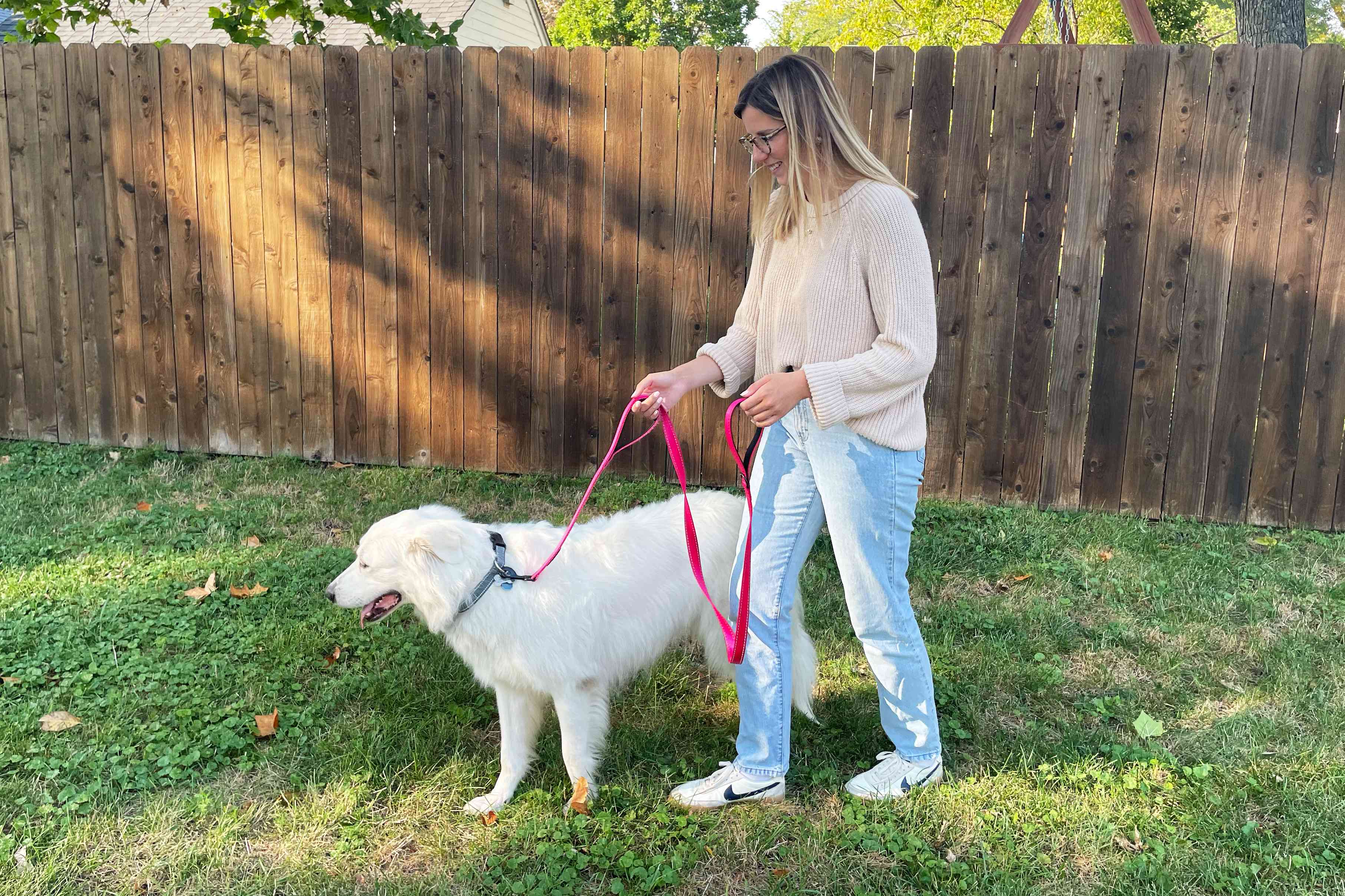 woman next to white dog on the Primal Pet Gear Double Handle Dog Leash in backyard