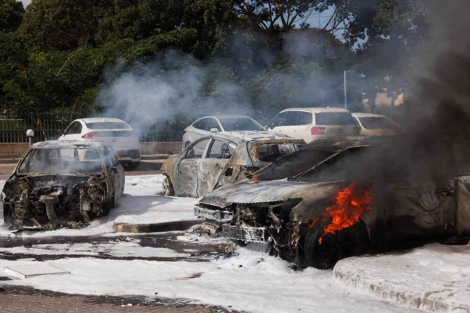 Cars are seen on fire following a rocket attack from the Gaza Strip in Ashkelon, southern Israel, on October 7, 2023.