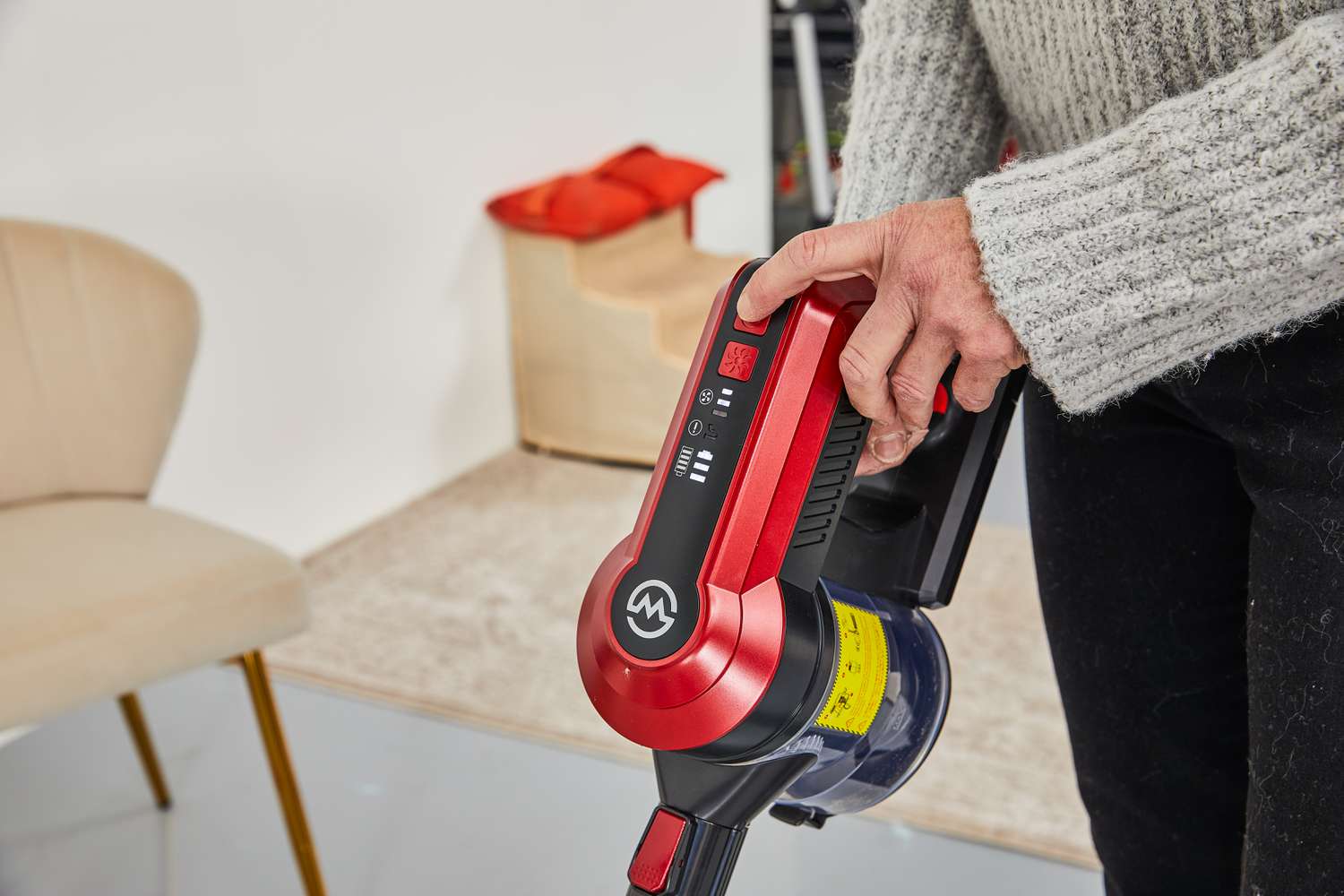 Person pressing a button on the Moosoo K23 Pro Cordless Stick Vacuum