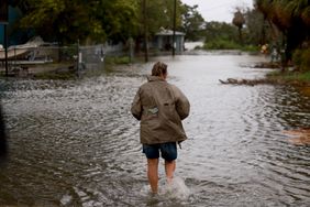  person walks through a flooded street caused by the rain and storm surge from Hurricane Debby on August 05, 2024, in Cedar Key, Florida