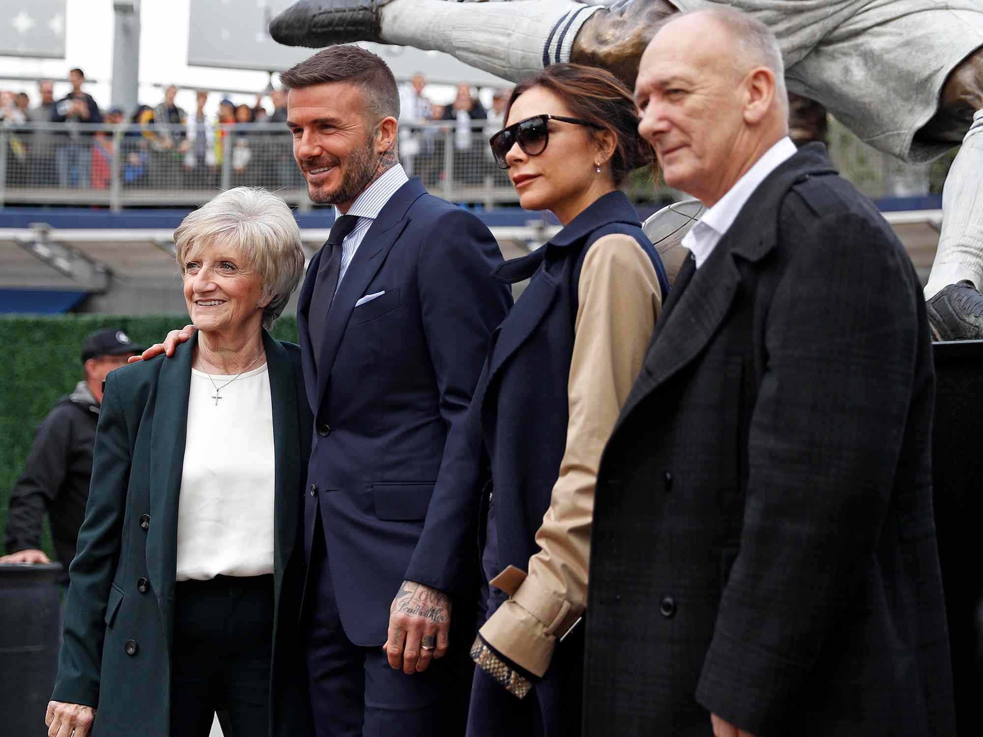 David Beckham poses with his wife Victoria Beckham and parents for a photo with his statue at Dignity Health Sports Park on March 02, 2019 in Carson, California