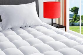 The Texartist Queen Cooling Mattress Topper on a bed in a bedroom