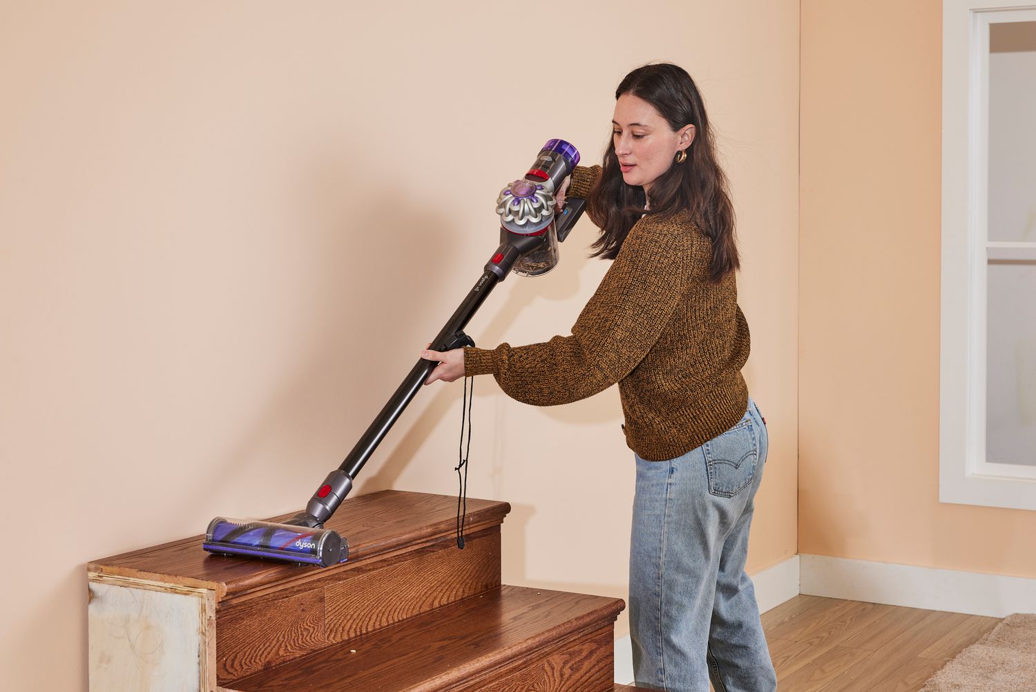 A person using the Dyson V8 on stairs