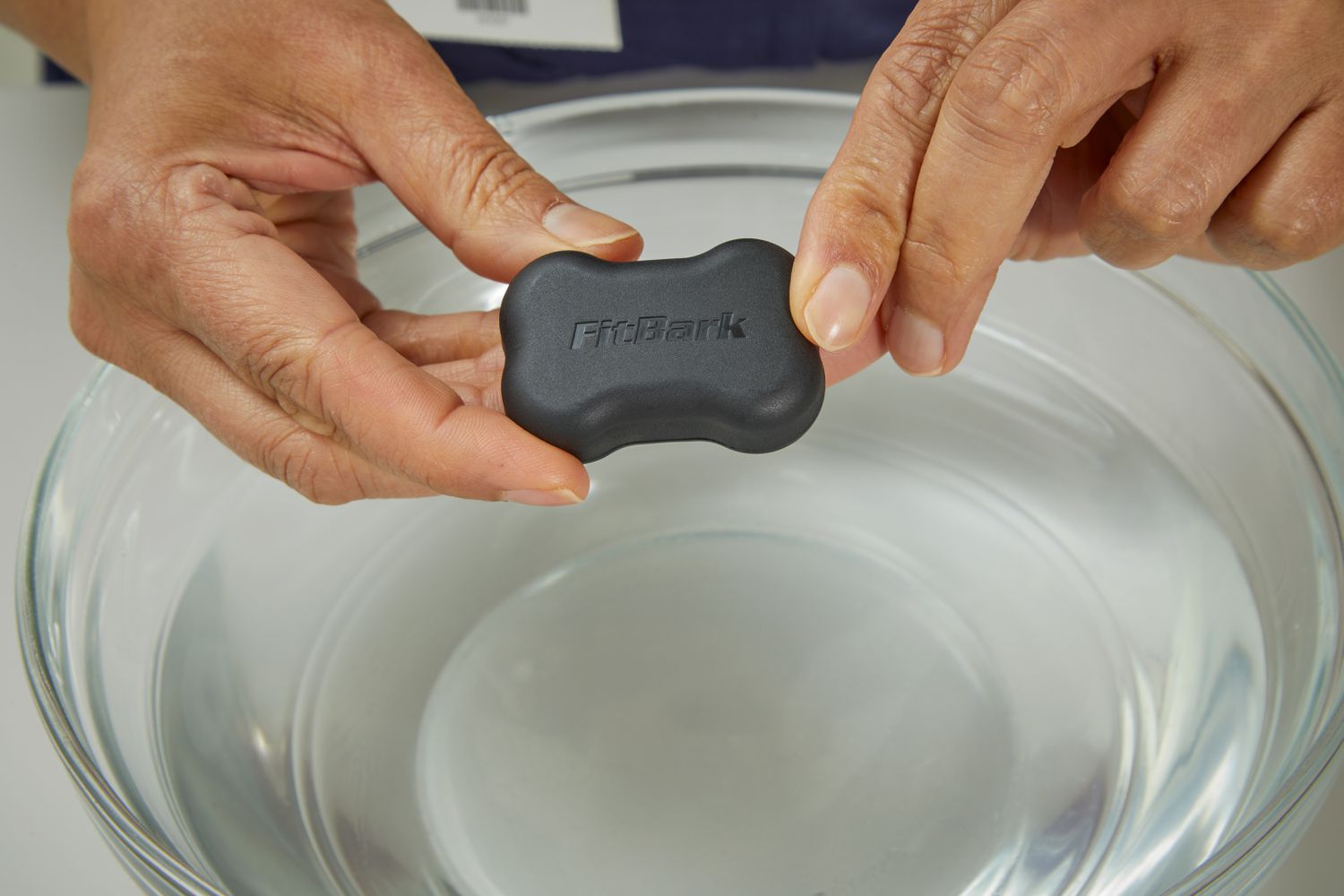 person holding FitBark GPS Dog Tracker (2nd Generation) over water bowl