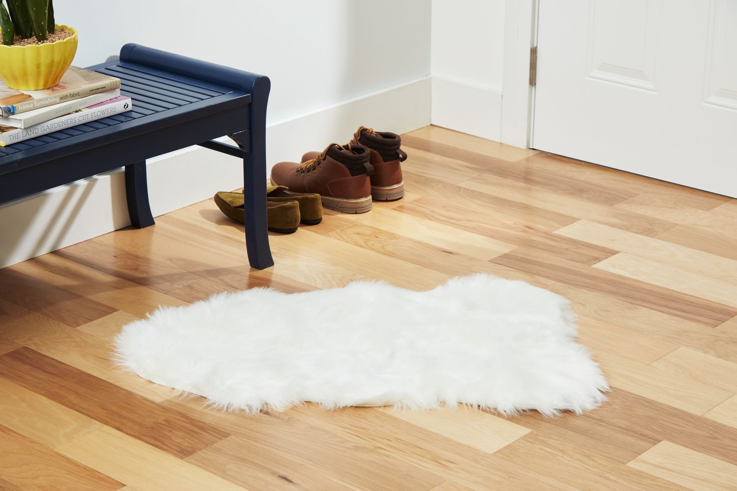 The Ashler Faux Fur Rug on a wooden floor