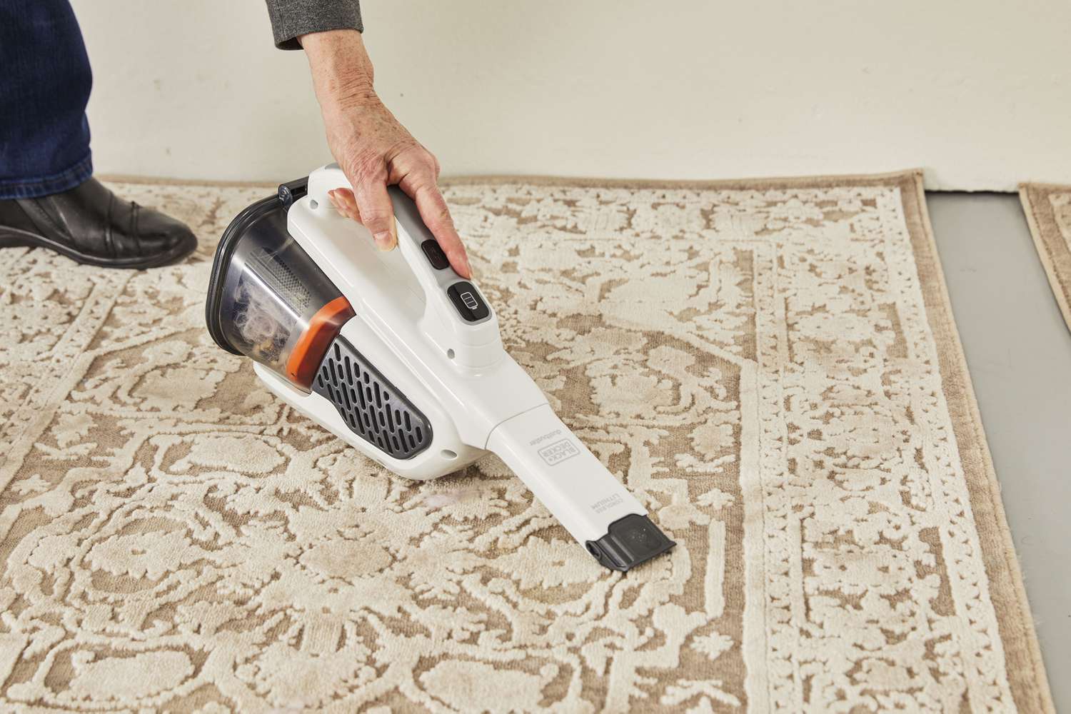 Person cleaning dust on carpet using Black+Decker Gen11 AdvancedClean+ Dustbuster