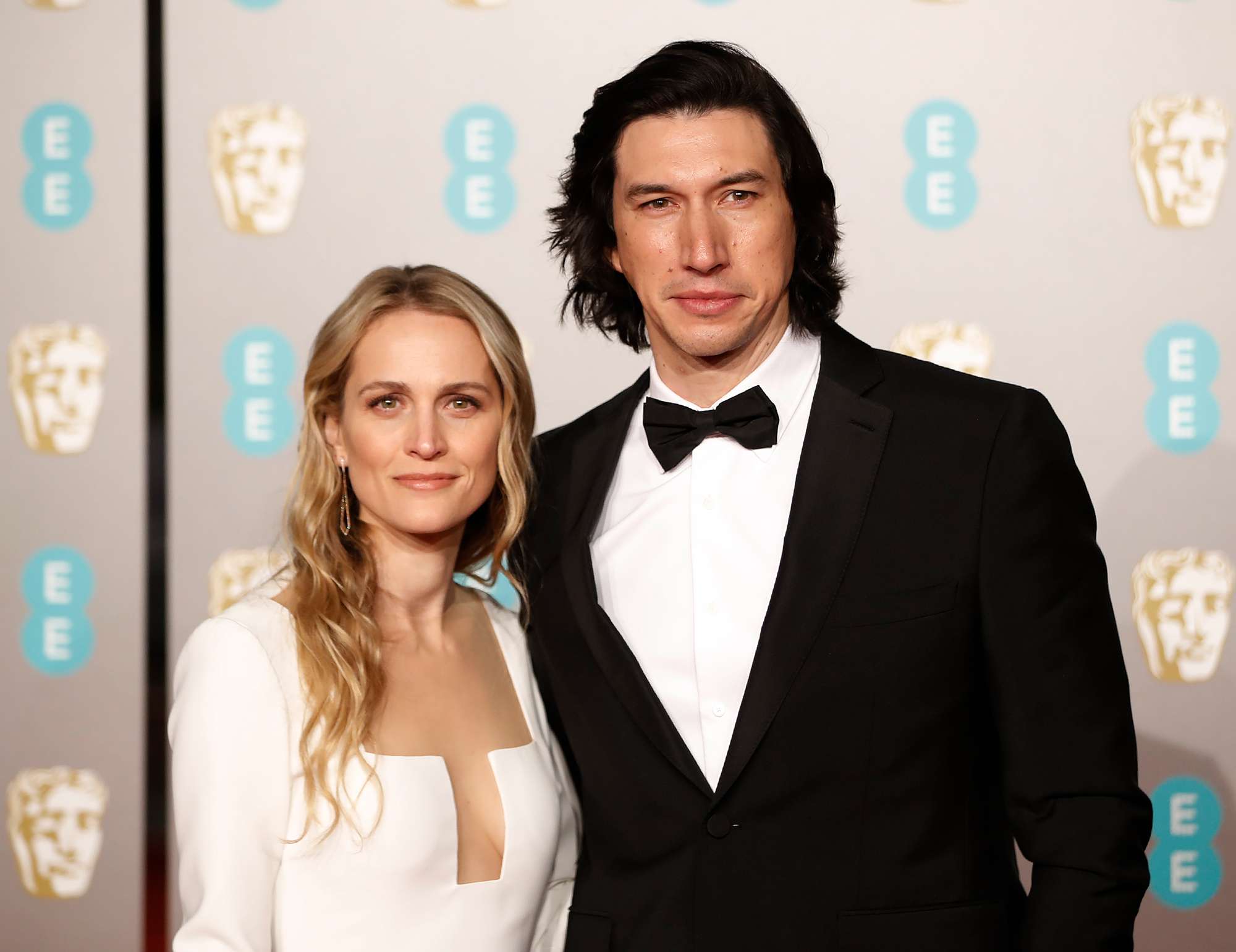 Joanne Tucker (L) and Adam Driver (R) pose on the red carpet upon arrival at the BAFTA British Academy Film Awards at the Royal Albert Hall in London on February 10, 2019