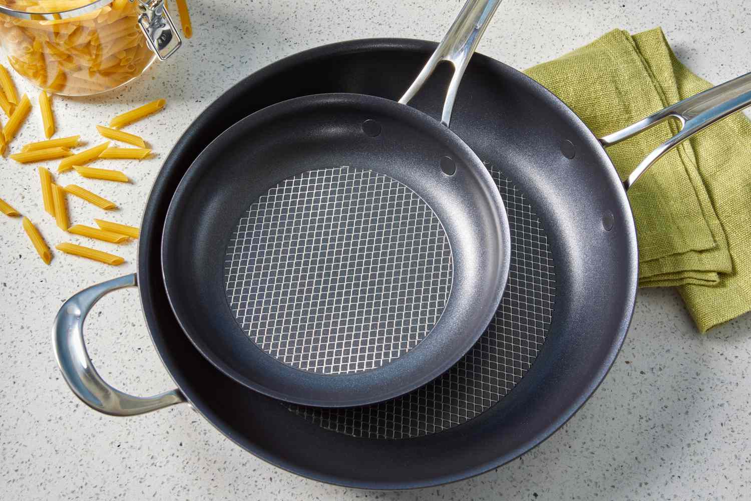 Stacked Anolon X Hybrid 10-Piece Nonstick Cookware Set frying pans displayed on countertop