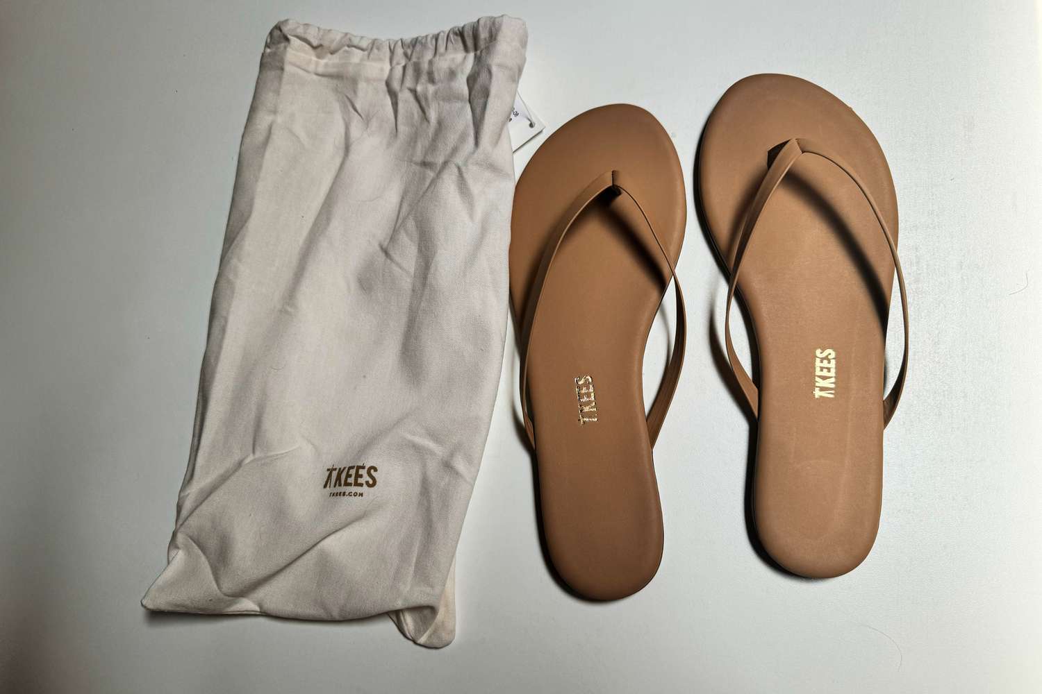 Tkees Flip-Flop Sandals next to portable bag 