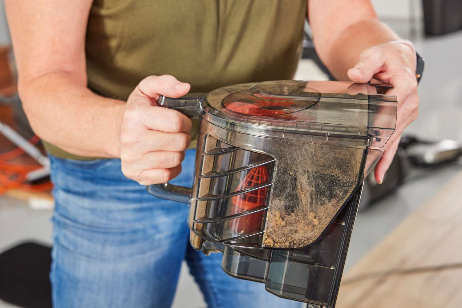 A person shows the dirt vacuumed by the Aspiron Canister Vacuum