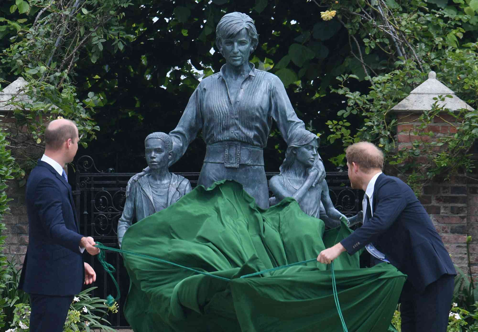 Prince William, Duke of Cambridge (L) and Britain's Prince Harry, Duke of Sussex unveil a statue of their mother, Princess Diana at The Sunken Garden in Kensington Palace, London on July 1, 2021