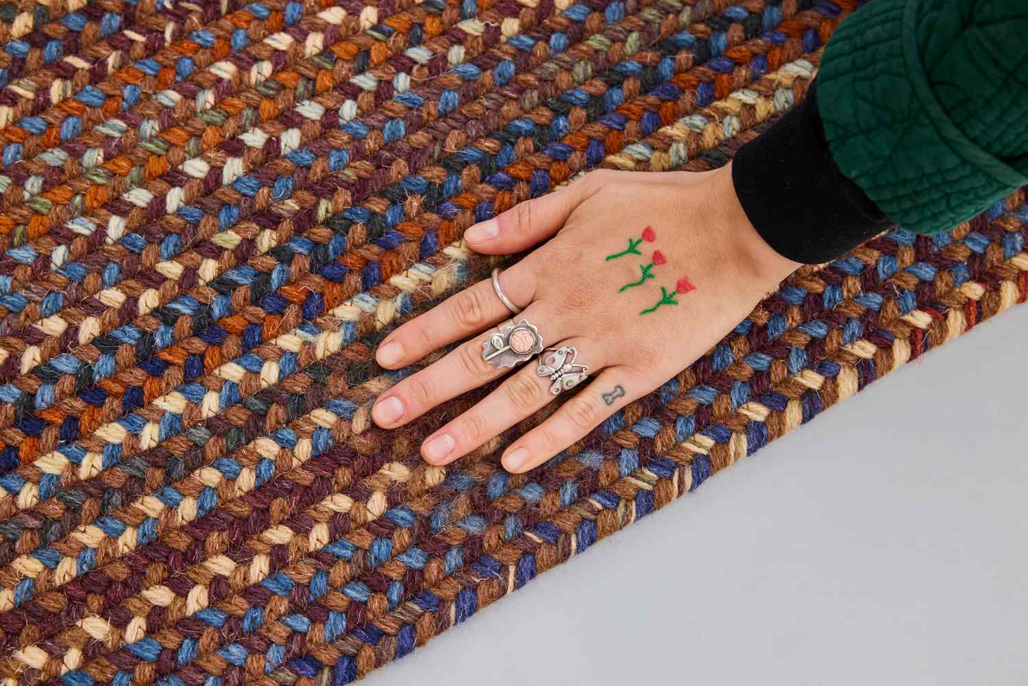 A person touches the L.L.Bean Braided Wool Rug, Oval