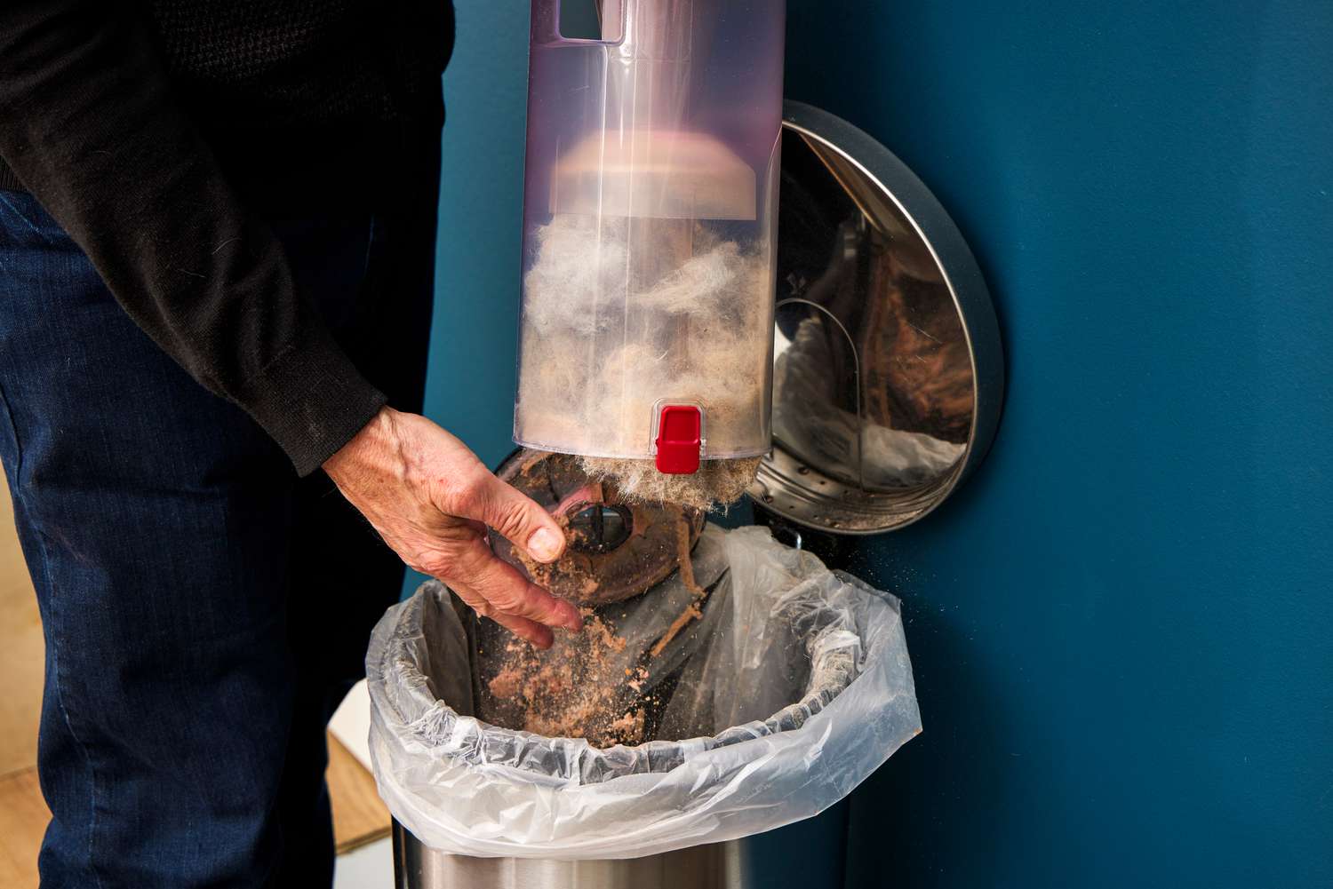 A person empties the canister on the Kenmore Allergen Seal Bagless Upright Vacuum