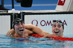 Torri Huske (L) celebrates with US' Gretchen Walsh after winning the final of the women's 100m butterfly swimming event during the Paris 2024 Olympic Games at the Paris La Defense Arena in Nanterre, west of Paris, on July 28, 2024