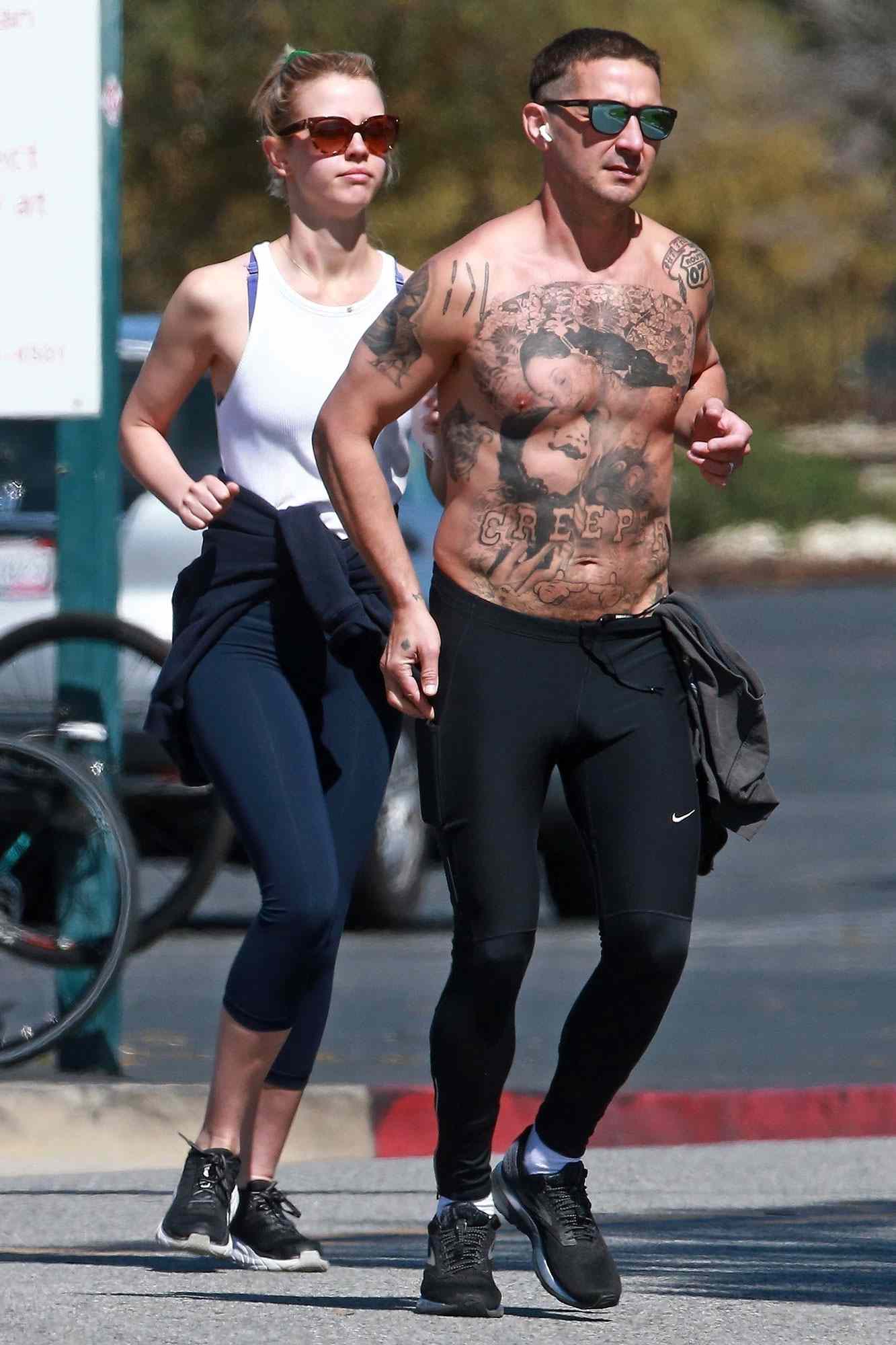 Shia LaBeouf puts his tattooed chest on display as he goes for a leisurely run with his ex wife Mia Goth