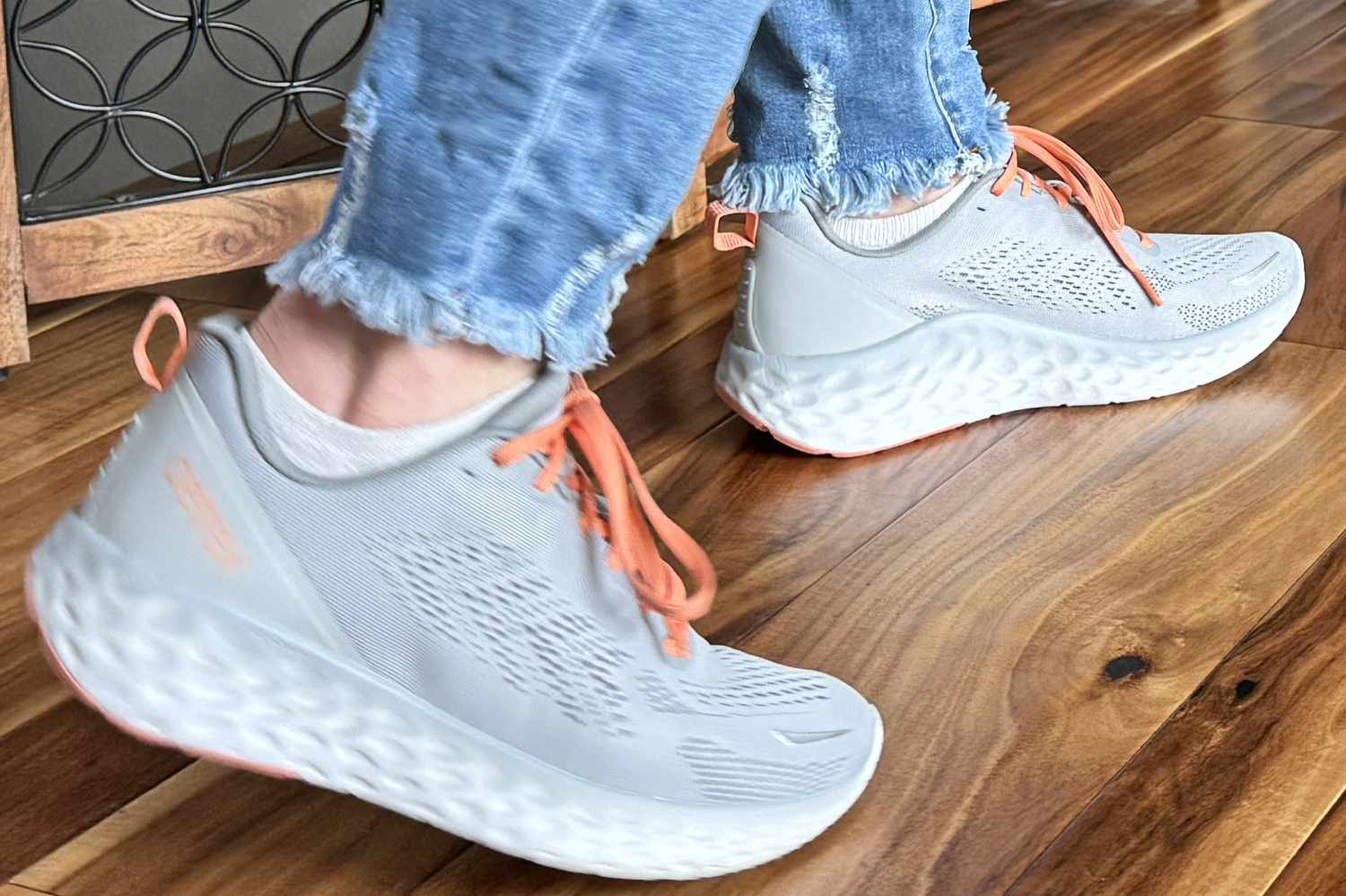 A person walks across a wooden floor while wearing the Aetrex Danika Arch Support Sneaker