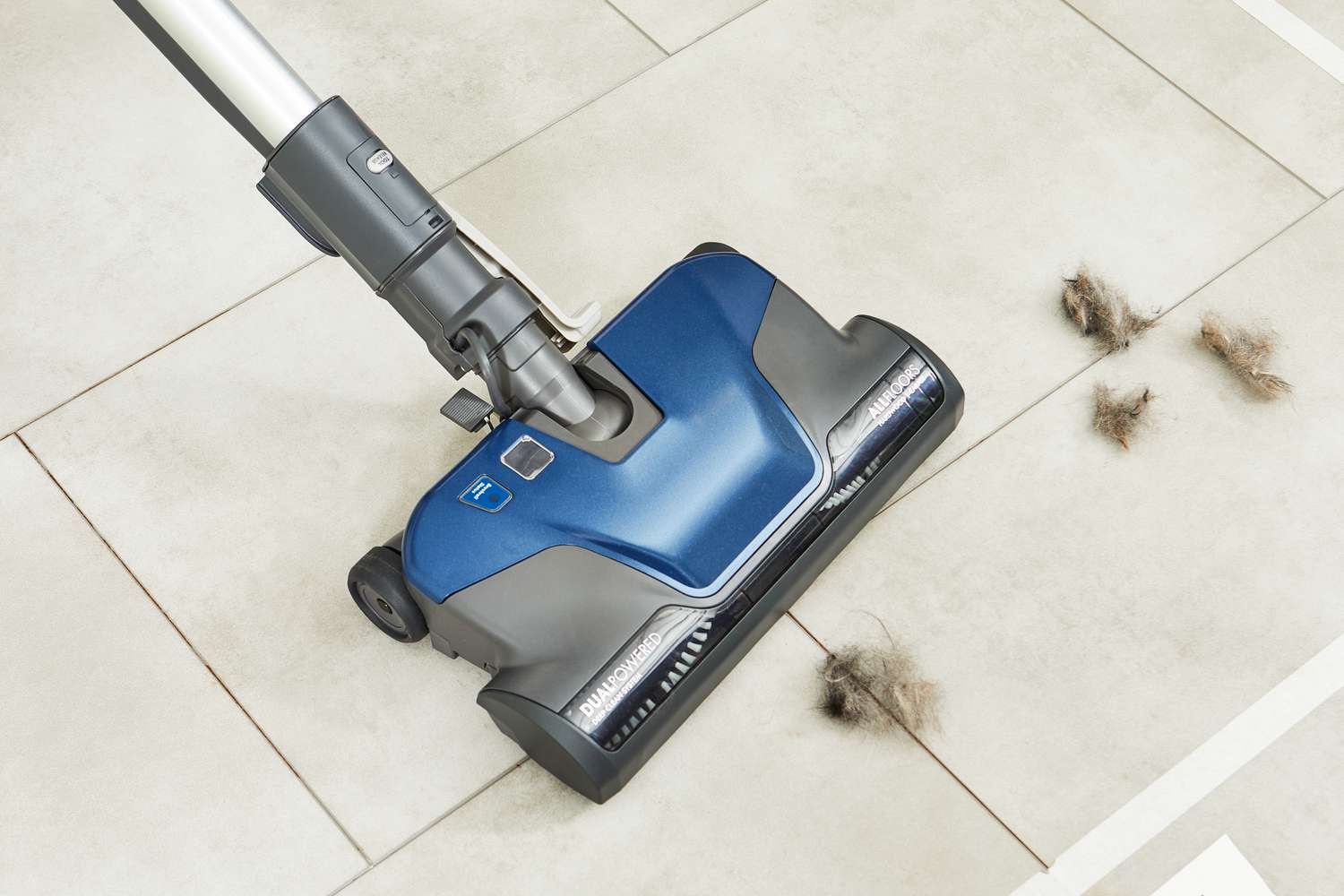 Kenmore Pet Friendly Pop-N-Go Bagged Canister Vacuum being used to clean up pet fur from white tile flooring