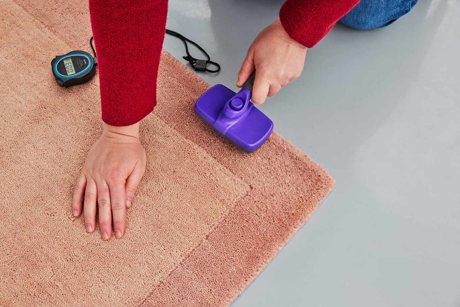 A person brushes the GreenRow Rhodes Solid Rug