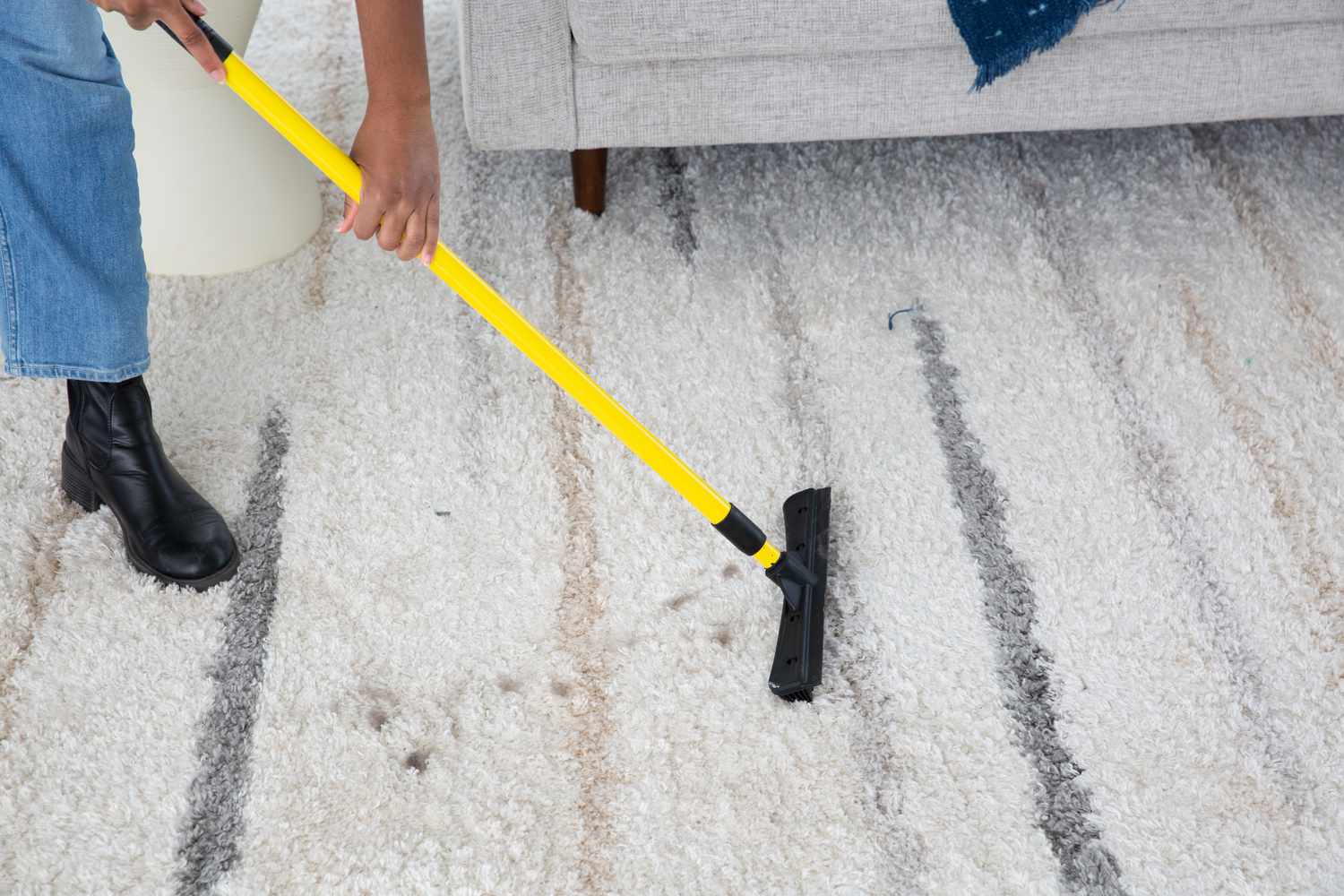 Person using a Evriholder FURemover Pet Hair Removal Broom on a fluffy carpet