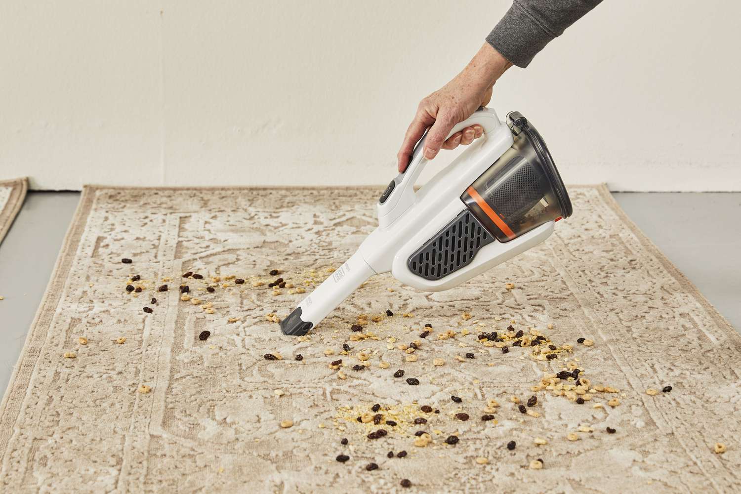 Person cleaning dust on carpet using Black+Decker Gen11 AdvancedClean+ Dustbuster