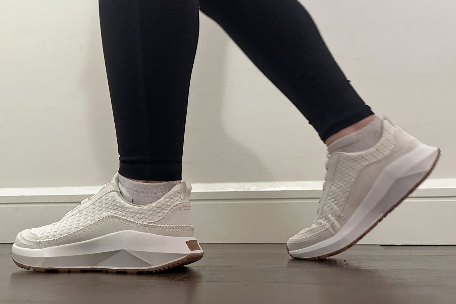 A person walks on a wood floor while wearing the Dr. Schollâs Hannah Sneaker