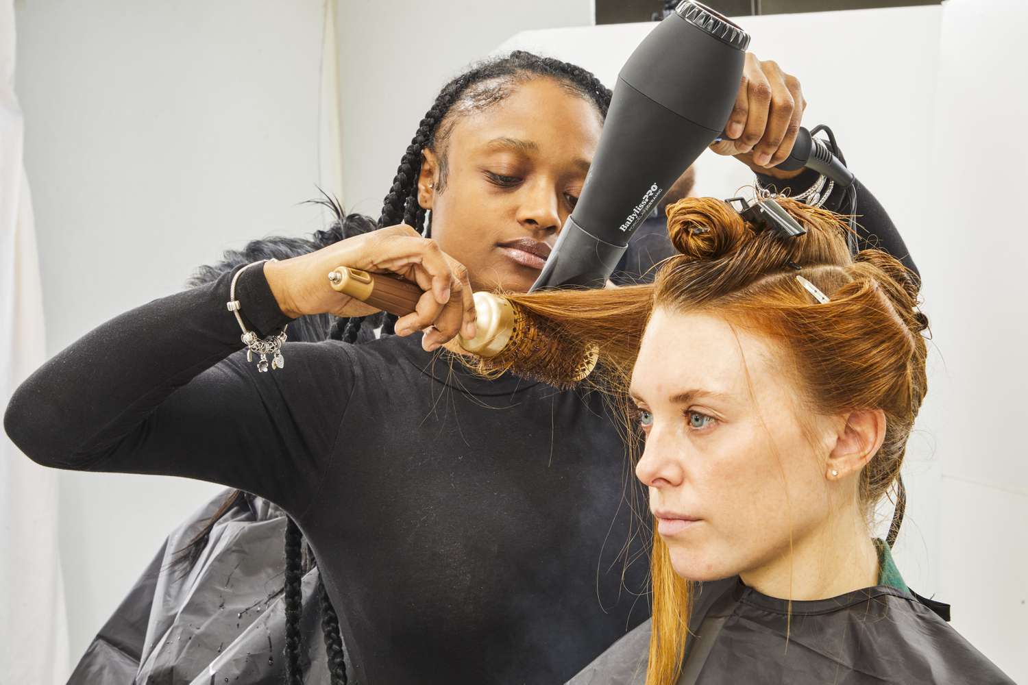 Person using BaBylissPRO Porcelain Ceramic Carrera2 Dryer and a brush to dry another person's hair