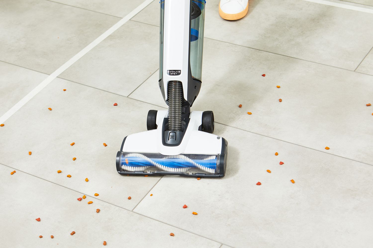 Person using Hoover Onepwr Evolve Pet Cordless Vacuum to clean food from tile