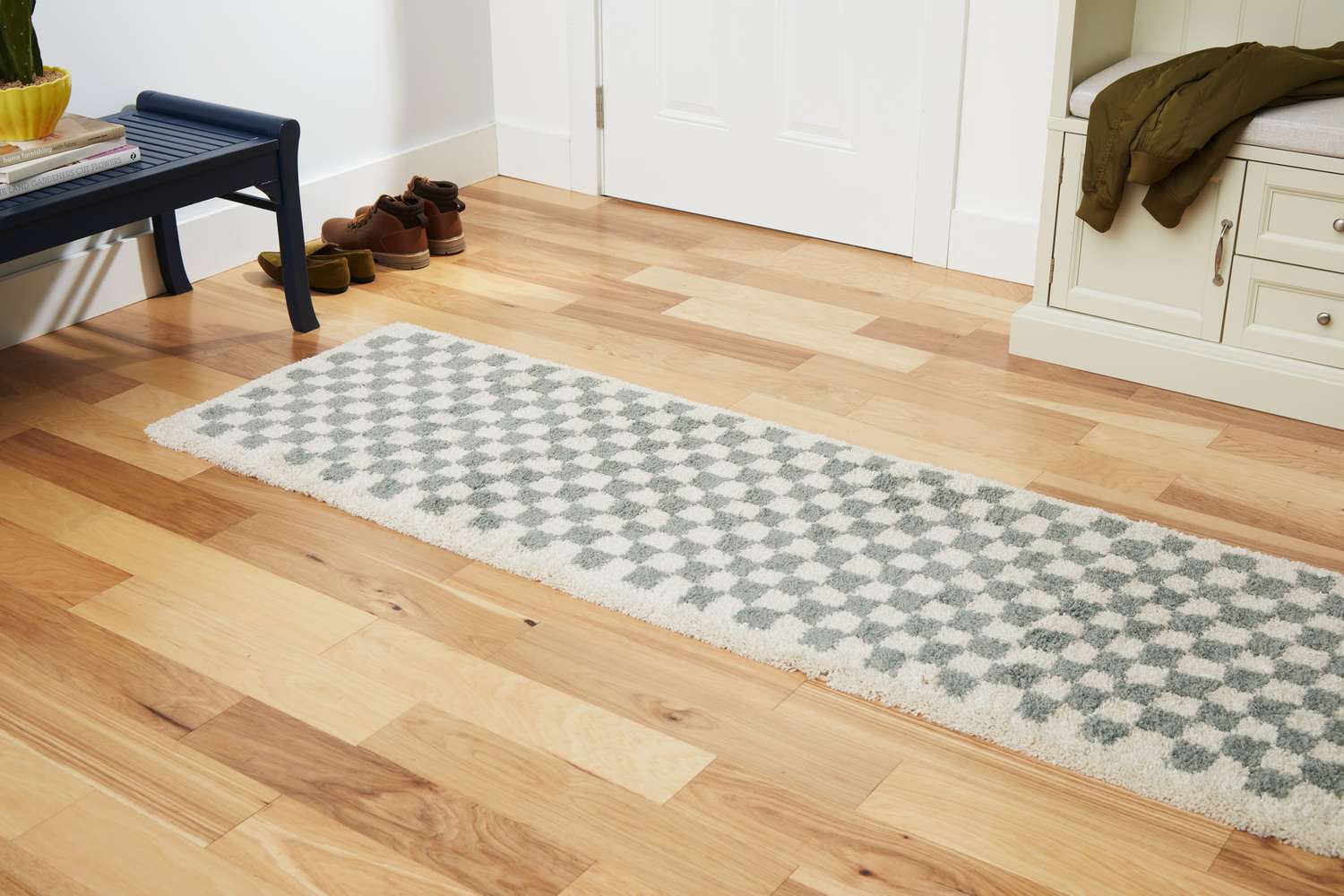 The AllModern Walker Checkered Shag Area Rug on a wooden floor