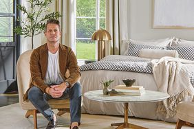 Nate Berkus sitting on a chair next to a bed