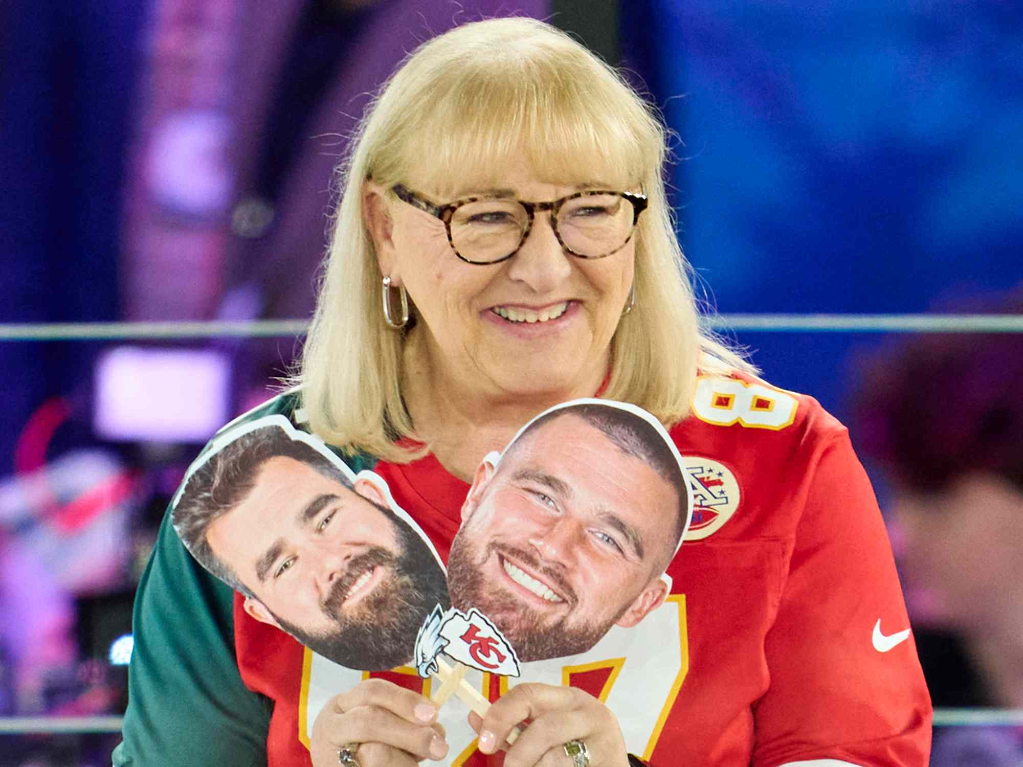 Donna Kelce holds up photos of her sons, Jason Kelce #62 of the Philadelphia Eagles and Travis Kelce #87 of the Kansas City Chiefs at Footprint Center on February 6, 2023 in Phoenix, Arizona