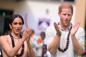 Prince Harry and Meghan gesture as they visit children at the Lights Academy in Abuja, Nigeria, Friday, May 10, 2024. Prince Harry and his wife Meghan have arrived in Nigeria to champion the Invictus Games, which he founded to aid the rehabilitation of wounded and sick servicemembers and veterans. 